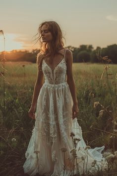 a woman standing in a field wearing a dress