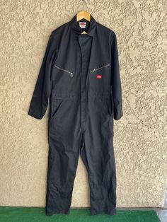 "Vintage black coveralls jumpsuit Made by Dickies The tag says size 44. Fits and measures like a large 65% Polyester 35% Cotton It has a zipper going down the front for easy slip-in and a couple of snaps. 10 pockets! It looks like it's never been worn and is in fabulous condition. Measurements laying flat Armpit to armpit 22\" (44\" total) Across the waist 19\" (38\" total) Total length of jumpsuit 62\" Items are shipped out within 1-2 business days. If you have any questions please feel free to Black Utility Overalls With Side Pockets, Black Overalls With Pockets, Black Overalls With Bib Front And Pockets, Casual Black Long Sleeve Overalls, Black Long Sleeve Casual Overalls, Black Bib Front Utility Overalls, Black Utility Overalls With Bib Front, Black Utility Overall Jumpsuits, Black Utility Overall Jumpsuits And Rompers