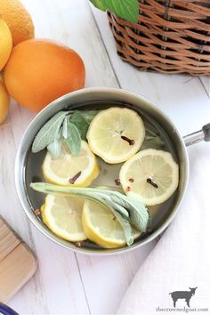 lemons and sage are in a bowl next to oranges