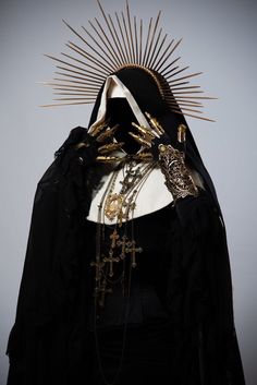 an image of a woman wearing a black outfit with gold decorations on her head and face