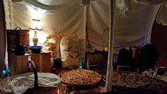 a room with a table and some food on the floor next to a bed covered in white sheets