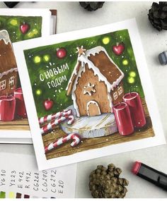 two christmas cards with gingerbread houses and candy canes next to some crayons