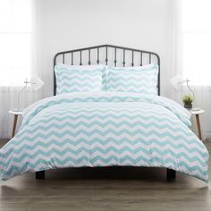 a bed with white and grey chevrons on it