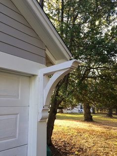 the corner of a house with a tree next to it