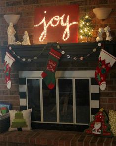 a fireplace with stockings hanging from it's mantle and the word joy spelled on top