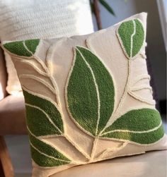 a green and white pillow sitting on top of a chair