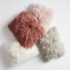 three different colored pillows sitting on top of each other