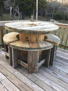 an outdoor table made out of wooden pallets on a deck with benches around it