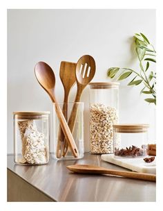 wooden spoons, measuring spoons and other kitchen utensils on a counter