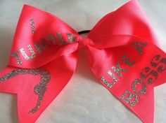 a red cheer bow with silver glitter words on it