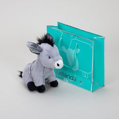 a small stuffed donkey sitting next to a blue bag with the word amanda on it