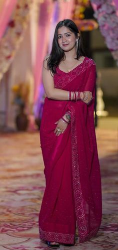 a woman in a red sari posing for the camera