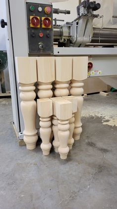 several wooden posts are stacked on top of each other in front of a milling machine