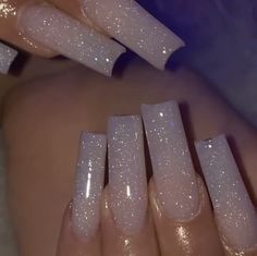 a woman's nails with white glitter on them