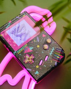 an electronic device is lit up with pink neon lights and designs on the back cover