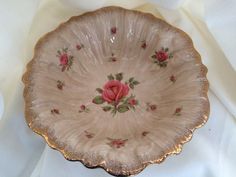 a pink flowered bowl sitting on top of a white table cloth