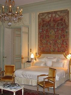 a bed room with a neatly made bed and a chandelier