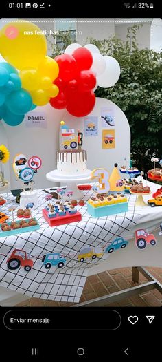 a table topped with lots of cake and balloons