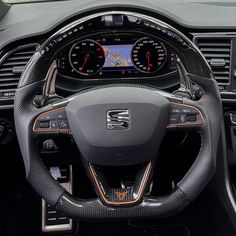 the interior of a car with steering wheel and gauges