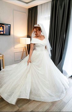 a woman in a white wedding dress is posing for the camera