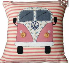 a pink and white striped pillow with a vw bus on the front, embroidered onto it