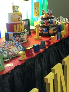 a table topped with lots of cakes and cupcakes