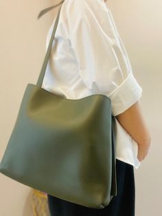 This practical and stylish olive green tote bag is perfect for those who love simple yet functional accessories. Made from sturdy faux leather, it's a great companion for your everyday needs without compromising on style. Features: Color: Subtle olive green Material: Durable faux leather with a smooth texture Interior: Comes with a handy, matching pouch for easy organization Design: Simple, unembellished design with a focus on functionality Size: Spacious enough for your daily essentials like books, a wallet, or makeup Usage: Ideal for casual outings, shopping, or as a daily work bag Why you'll love it: This tote offers a clean and minimal look, making it perfect for everyday use. It's lightweight, easy to carry, and comes with an extra pouch to help keep your smaller items organized. Texture Interior, Organization Design, Green Minimalist, Green Tote Bag, Vegan Leather Tote Bag, Green Tote, Vegan Leather Tote, Easy Organization, Women Handbag