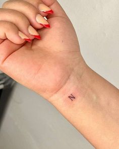 a woman's arm with a small tattoo on the left side of her wrist