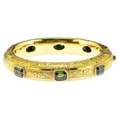 This outstanding antique bangle is Victorian era, 1880 circa Magnificent workmanship of the era adorned throughout with artful carving making it quite an unique, stamped 18 KT – 41 grams in weight Set with 6 natural untreated Tourmaline – octagonal emerald cut – rich Forest Green and beautiful making a total content of 10.20 Ct Bangle is in perfect condition and will fit any standard measure wrist

Rare and stunning example, great addition at any collection standard Further Details Below Metal: 18 Kt yellow gold Hallmarks: assay Gems: 6 emerald cut natural tourmaline green color totaling approx 10.20 Ct(8.19 x 6.49 mm. - average) Measures: width is 13 mm. (h. x w.) Weight: 41 grams Condition: very good commensurate to age and use Weight Set, Green Tourmaline, Victorian Era, Emerald Cut, Forest Green, Tourmaline, Bangle Bracelets, Jewelry Bracelets, Emerald