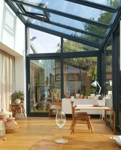 a dining room with glass walls and wooden floors