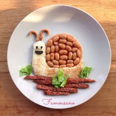 a plate that has some kind of food on it with beans in the shape of a snail