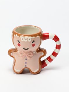 a ceramic mug with a ginger on the side and a candy cane in its mouth