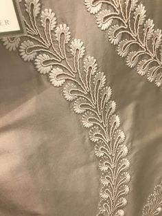 an embroidered fabric with white flowers on it