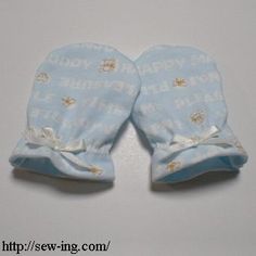 two blue baby mitts with white writing on them