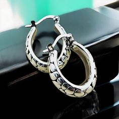 Elevate your jewelry collection with our exquisite Lightweight Oval Cobblestone Design Hoop Earrings, meticulously crafted from premium 925 Sterling Silver. Each earring boasts a delicate hollow construction, ensuring both comfort and elegance. The dimensions of these sophisticated hoops are approximately 18.5 mm in width and 21.4 mm in length, offering a striking presence without overwhelming. They are subtly stamped with '925' to certify their sterling silver composition. Experience the perfec Elegant Tarnish Resistant Silver Hoop Earrings, Luxury Silver Tarnish-resistant Huggie Earrings, Elegant Silver Tarnish-resistant Hoop Earrings, Silver Huggie Fine Jewelry, White Gold Oval Earrings Tarnish Resistant, Oval White Gold Earrings Tarnish Resistant, Oval White Gold Tarnish-resistant Earrings, Silver Sterling Silver Hoop Earrings Tarnish Resistant, Nickel-free Elegant Huggie Earrings