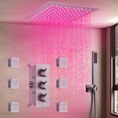 a shower head with pink water running down it's side and thermostaers on either side