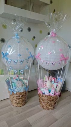 two baskets filled with baby items sitting on top of a wooden floor