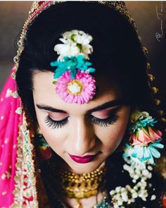 a woman with flowers in her hair and makeup