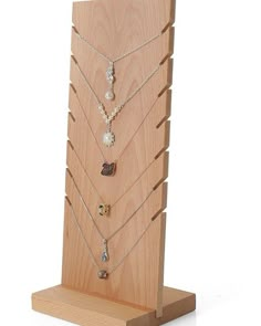 a wooden display case with several necklaces on it