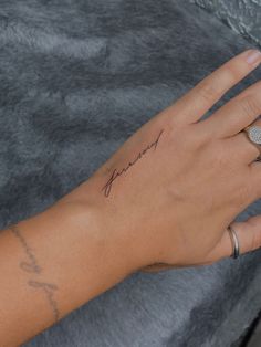 a woman's hand with a tattoo on her left wrist and the word love written in cursive writing