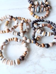 Earthy, natural, cozy, and everyday. Beautiful beige, white, cream, brown, and touches of sienna and rust in these mixed medium stack bracelets. Several gemstone varieties in different sizes, finishes, and colors. 10mm Matte Fossilized Coral, 8mm Picture Jasper rondelle, and many ethical bone beads in a variety of colors and shapes. Mix these in with recycled glass, Kente Krobe sand glass beads, shell, coconut disks, and mixed metals. Unique and stunning. Strung on heavy duty elastic. The item/s Rustic Brown Hand-wrapped Beaded Bracelets, Rustic Brown Hand Wrapped Beaded Bracelets, Rustic Brown Beaded Bracelets With Wooden Beads, Handmade Brown Bracelet For Everyday, Earthy Brown Bracelets With Wooden Beads, Handmade Brown Bracelets For Everyday, Handmade Earthy Brown Beaded Bracelets, Earthy Brown Wooden Bead Bracelets, Handmade Brown Everyday Bracelets