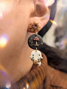 a close up of a person's face wearing earring with an animal on it