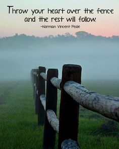 a fence in the grass with a quote on it that says, throw your heart over the fence and the rest will follow