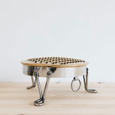 a wooden table topped with a metal tray covered in lots of riveted items