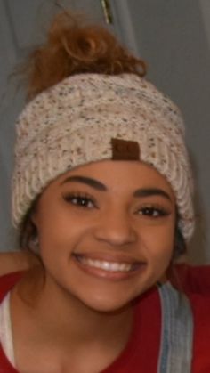 a young woman wearing a knitted hat and smiling