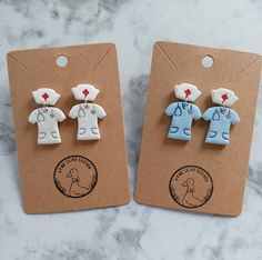 two small wooden buttons with nurse's clothes on them