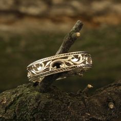 two silver rings sitting on top of a tree branch