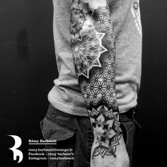 black and white photo of a man's arm with an intricate tattoo design on it