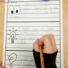 a person holding a pencil in front of a paper that has writing on it and an image of a lightbulb