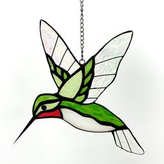 a stained glass hummingbird hanging from a chain